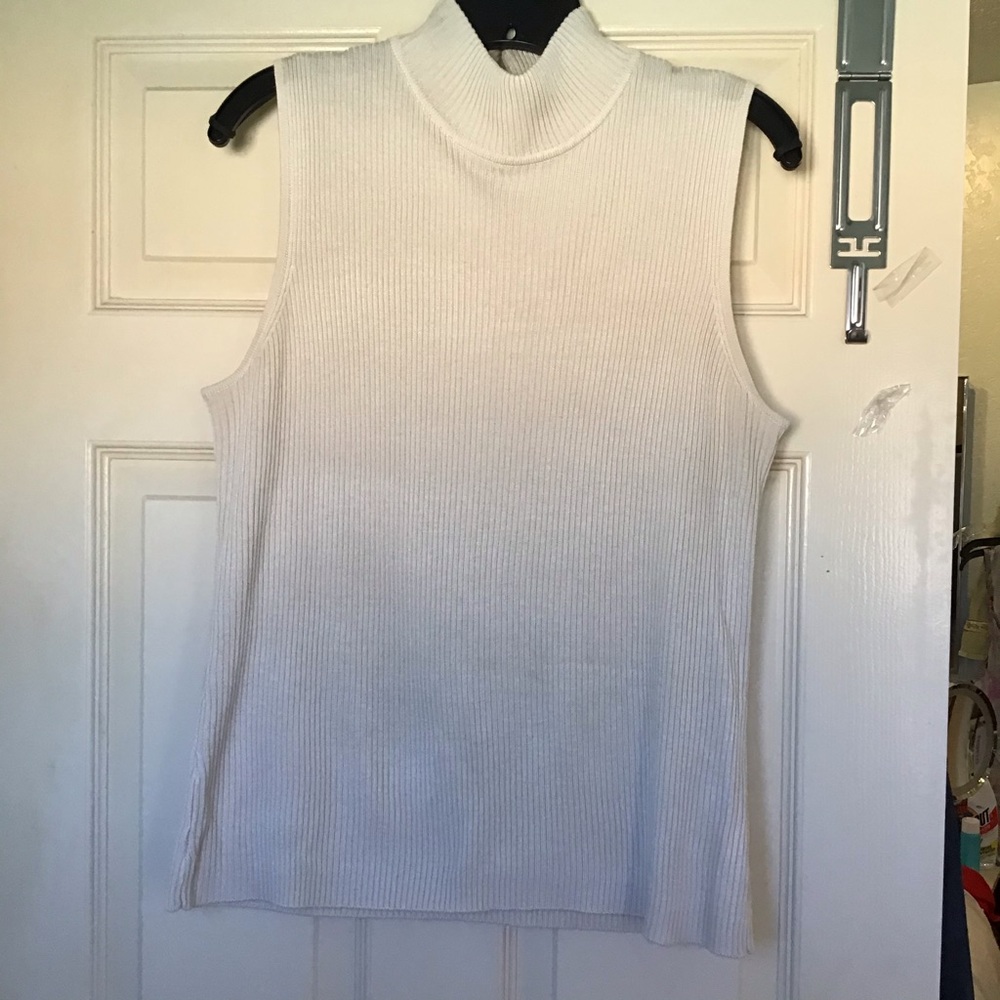 Cream color ribbed sleeveless turtleneck.